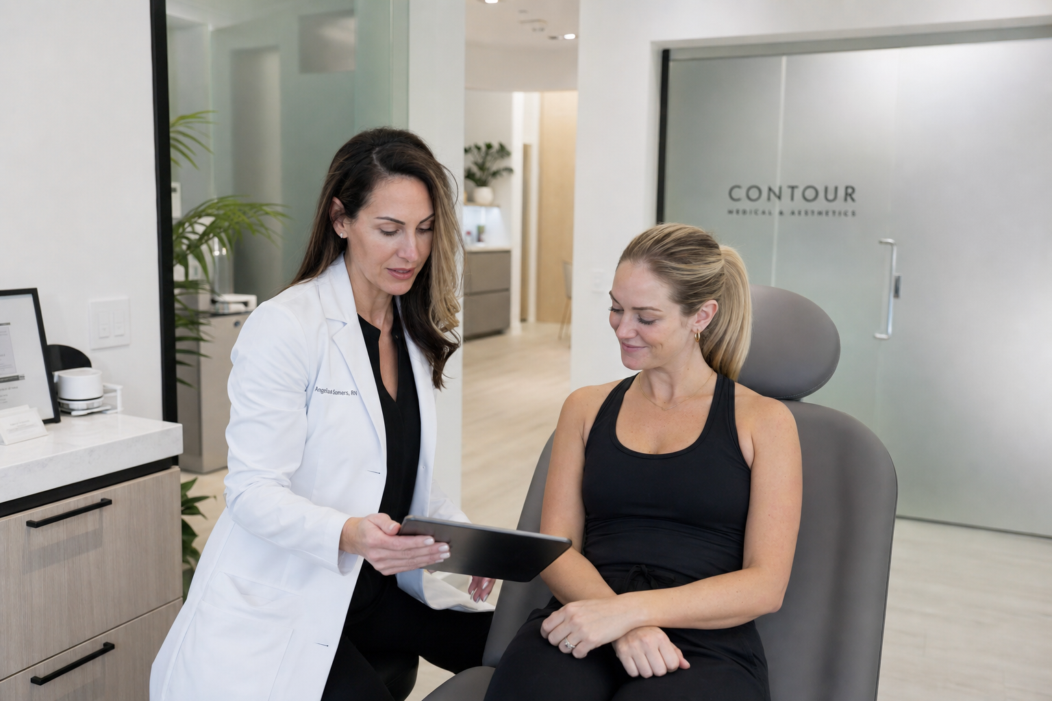 Registered nurse in white lab coat reviewing a wellness plan with a calm female client in a modern Yorkville clinic