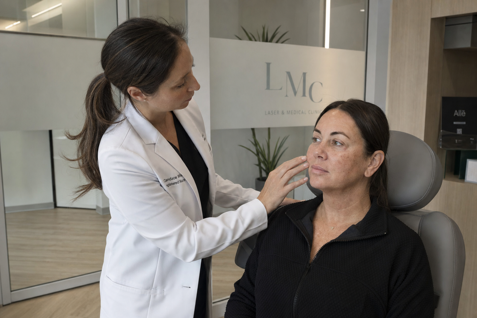 Registered nurse assessing a calm female client's pigmentation before treatment in a minimalist Toronto clinic